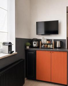 a kitchen with a counter with a tv on the wall at Rheinischer Hof Duisburg in Duisburg +3 photos