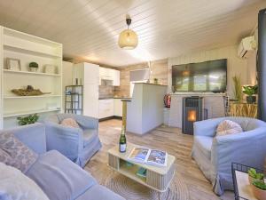 a living room with two blue couches and a kitchen at Barri in Zutendaal