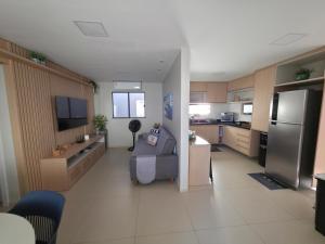 a large kitchen with a couch and a refrigerator at Refúgio à Beira-Rio em Condomínio Exclusivo in Barreirinhas