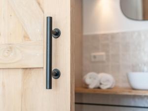 a wooden door with a black handle in a kitchen at Zilte Suite in Oostkapelle