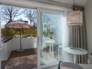 a sliding glass door leading to a patio with an umbrella at Zilte Suite in Oostkapelle