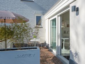 a patio with a table and an umbrella at Zilte Suite in Oostkapelle