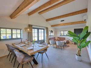 a dining room with a wooden table and chairs at Guesthouse het Koetshuis in Bladel