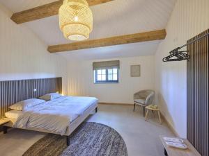 a bedroom with a large bed and a chair at Guesthouse het Koetshuis in Bladel