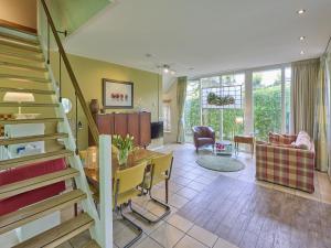 a living room with a staircase and a dining room at Wellnesshuisje Engelse Tuin in Oldenzaal
