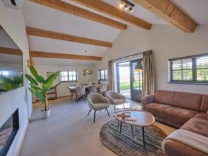 a living room with a couch and a table at Guesthouse het Koetshuis in Bladel