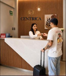 a man and a woman standing at a counter at Centrica Suite Hotel in Huarmey