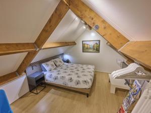 a small bedroom with a bed in a attic at Wellnesshuisje Engelse Tuin in Oldenzaal +51 photos