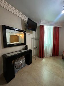 a living room with a television on the wall at Hotel kristal in La Barca