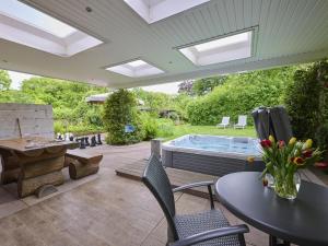 a patio with a table and chairs and a hot tub at Wellnesshuisje Engelse Tuin in Oldenzaal