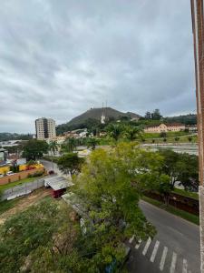 a view of a city with a hill in the background at Comodidade in Caxambu