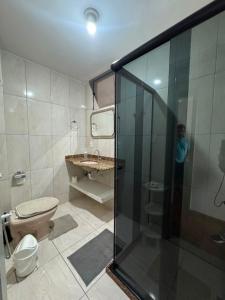 a man taking a picture of a bathroom with a shower at Comodidade in Caxambu +9 photos