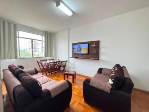 a living room with two couches and a table at Comodidade in Caxambu