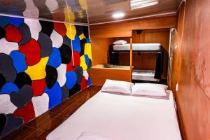 a small room with a bed and a painting on the wall at Blackout Party Hostel and Experiences in Fortuna
