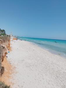 a beach with a lot of people and the ocean at Résidence R in Ksour Essaf