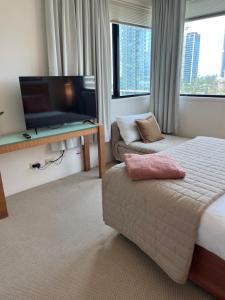 a hotel room with a bed and a flat screen tv at Broadbeach on the Park in Gold Coast
