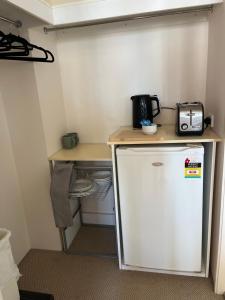 a small kitchen with a counter and a refrigerator at Broadbeach on the Park in Gold Coast