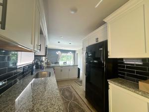a kitchen with a black refrigerator and a sink at Triple Crown KC in Kansas City