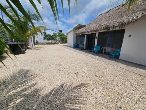 a house with a thatched roof and a gravel driveway at PLAYABRISAMAR in San Antero