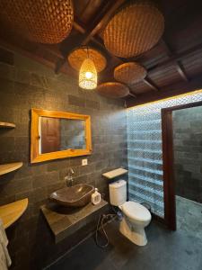 a bathroom with a sink and a toilet and a mirror at SinCity Nature Private Pool Villa in Tanjung +20 photos