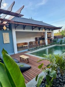 a house with a wooden deck and a swimming pool at SinCity Nature Private Pool Villa in Tanjung
