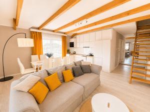 a living room with a gray couch and yellow pillows at Nowe Apartamenty Puck in Puck