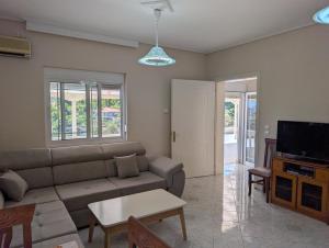 a living room with a couch and a tv at Vila Albert in Gjirokastër