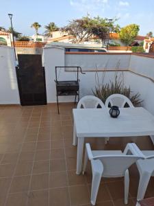 a patio with a white table and two chairs at Las Olas Corralejo beach in Corralejo