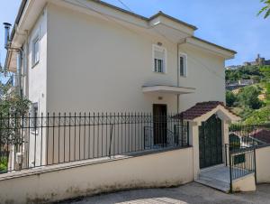 a white house with a gate and a fence at Vila Albert in Gjirokastër