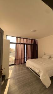 a bedroom with a bed and a large window at OASIS360 chalet in Sowayma
