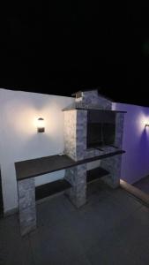a stone fireplace with a bench next to a wall at OASIS360 chalet in Sowayma