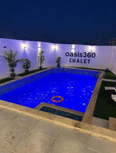 a large blue swimming pool in front of a building at OASIS360 chalet in Sowayma