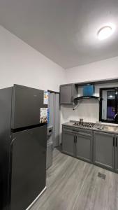 a kitchen with a black refrigerator and appliances at OASIS360 chalet in Sowayma