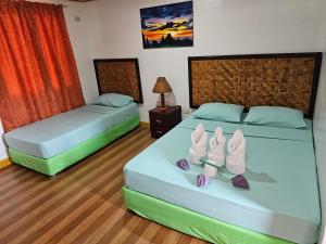 two beds in a room with shoes on them at Paraiso ni Ronin in Tagudin +36 photos