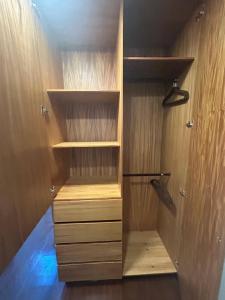 a closet with wooden shelves and wooden cabinets at Container Glamping in Zapopan