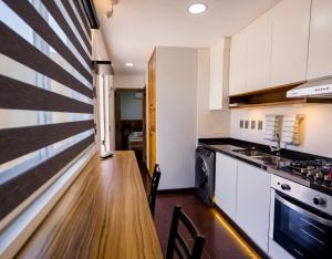 a kitchen with white cabinets and a wooden counter top at Container Glamping in Zapopan