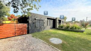 a modern house with a fence and a yard at Casitas Atlántida in Atlántida