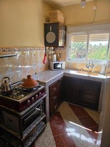 a kitchen with a stove and a sink at Desert Stars Oasis in Aoufous +2 photos