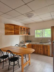 a kitchen with a wooden table and chairs at Paraiso ni Ronin in Tagudin