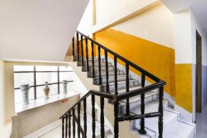 a staircase in a house with a black railing at Hotel O Priyal in Chās