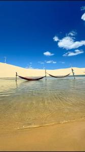two boats sitting in the water on a beach at Xodó de Casa, Paracuru in Paracuru