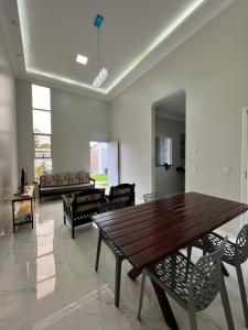 a living room with a wooden table and chairs at Xodó de Casa, Paracuru in Paracuru