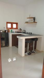 a kitchen with a counter with two stools at RUMAH BAIQ Villa in Kuta Lombok