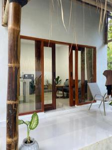 a living room with glass doors and a plant at RUMAH BAIQ Villa in Kuta Lombok
