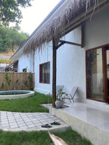 a house with a straw roof and a patio at RUMAH BAIQ Villa in Kuta Lombok