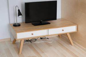 a television sitting on top of a wooden table at Amulet Poznan Old Town in Poznań
