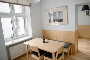 a dining room with a table and chairs and two windows at Amulet Poznan Old Town in Poznań