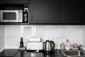 a kitchen counter with a microwave and a sink at Amulet Poznan Old Town in Poznań