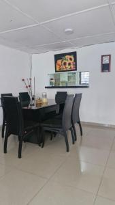 a dining room with a black table and chairs at Villa Salguero in Gaira