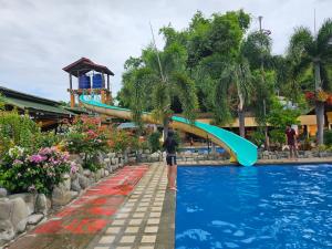 a person with a surfboard in a pool at a resort at Paraiso ni Ronin in Tagudin